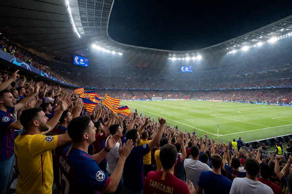 欧冠决赛夜球场灯光璀璨， thousands fans cheering in the stands